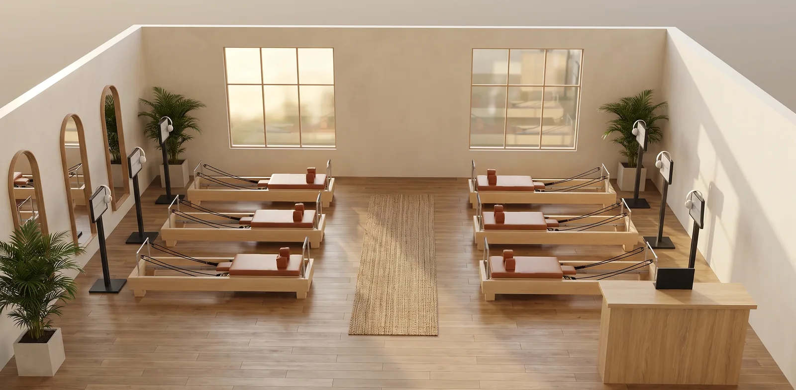 Rendu d'architecte d'un studio de Pilates Reformer digital de six postes : Reformers en érable et cuir cognac, un écran sur pied au pied de chaque Reformer, allée centrale, verrières, miroirs arrondis et accueil