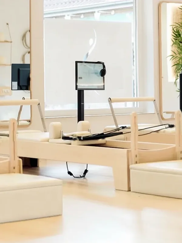Poste de studio : Reformer en érable sellerie blanche, box blanches, écran horizontal sur pied côté cordes, casque accroché